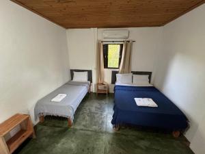 two beds in a small room with a window at Pousada Recanto Das Gerais in Carmo do Rio Claro +32 photos