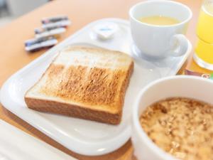 um prato branco com uma torrada e uma xícara de café em Hotel Excellence Kyoto Station Hachijo em Quioto