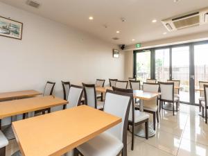 uma sala de jantar com mesas e cadeiras de madeira em Hotel Excellence Kyoto Station Hachijo em Quioto mais 31 fotografias