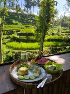 a plate of food on a table in front of a field at Tetebatu Hideaway in Tetebatu