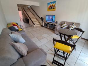 a living room with a couch and a television at Pontal Hostel Suite Ilhéus in Ilhéus