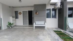 a white bench sitting outside of a house at Homestay Apamanis, Alor Setar in Kepala Batas +11 photos
