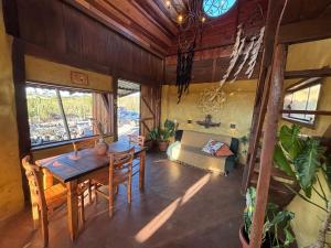 a dining room with a table and a couch at Cabana no coração do cerrado in Alto Paraíso de Goiás