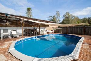 una piscina su una terrazza con tavolo e sedie di The Lake House - Waterfront Haven with Granny Flat a Karraganbah
