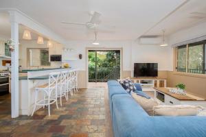 un soggiorno con un divano blu e una cucina di The Lake House - Waterfront Haven with Granny Flat a Karraganbah
