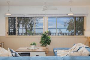 un soggiorno con un divano blu e una grande finestra di The Lake House - Waterfront Haven with Granny Flat a Karraganbah