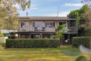 una casa con balcone e cortile di The Lake House - Waterfront Haven with Granny Flat a Karraganbah