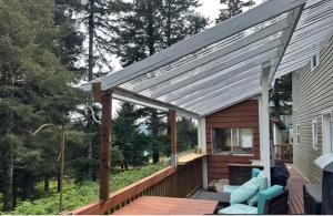 a wooden deck with a pergola on a house at Last Frontier Lodge - Forest, Mountain, Ocean Views in Kodiak