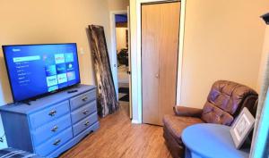 a living room with a tv on a dresser at Last Frontier Lodge - Forest, Mountain, Ocean Views in Kodiak