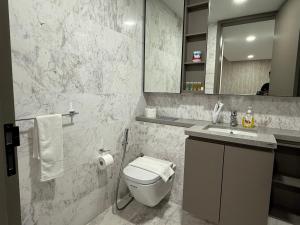 a bathroom with a toilet and a sink and a mirror at Eaton Residence Suites KLCC in Kuala Lumpur +40 photos