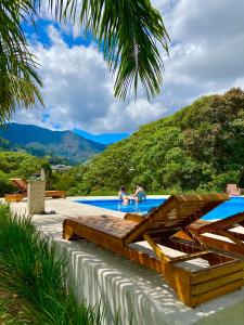a swimming pool with two people in the water at Pousada Altitude 1200 in Fazendinha