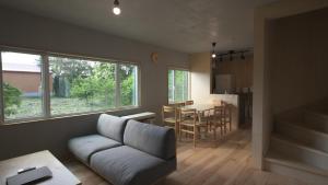 a living room with a couch and a table at Good Wood House Higashikawa in Higashikawa