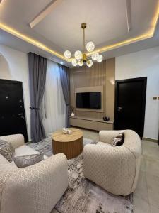 a living room with two chairs and a table at Sohana Homes in Ikeja +20 photos