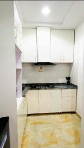 a kitchen with white cabinets and a tile floor at Sohana Homes in Ikeja