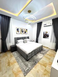 a bedroom with a large bed and a chandelier at Sohana Homes in Ikeja