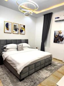 a bedroom with a large bed and a chandelier at Sohana Homes in Ikeja