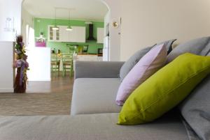 sala de estar con sofá y almohadas verdes y rosas en Villa Milu, en Quinto di Treviso