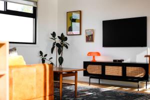 un soggiorno con una TV a parete di Up and Down Simple Comfort at Thornbury Townhouse a Melbourne