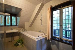 a bathroom with a tub and two sinks and a window at La Neige Nishikan in Hakuba +70 photos