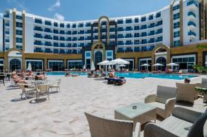 カーギジャックにあるThe Lumos Deluxe Resort Hotel & Spaの大きな建物で、周りに座る人々が集まるプールがあります。