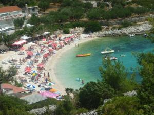 a beach with a bunch of people in the water at Apartments Mazuran in Hvar +5 photos