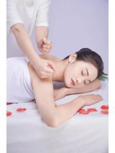 Ein Mann massiert eine Frau auf einem Bett in der Unterkunft Vienna Hotel Fuzhou Mawei Banzheng Cultural Scenic Area Branch in Fuzhou