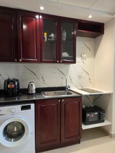 una cucina con lavello e lavatrice di Breeze Studio & Golf view, pool, gym & identity renew a Ras al Khaimah