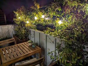 un patio con panca e alcune piante e luci di Up and Down Simple Comfort at Thornbury Townhouse a Melbourne Altre 9 foto