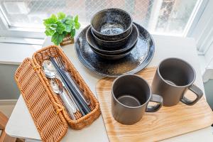une table avec deux tasses et un plateau avec des ustensiles dans l'établissement japan house edogawabashi 2, à Tokyo 100 autres photos