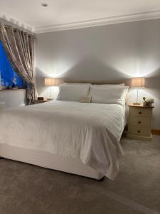 a bedroom with a large white bed and two lamps at Prime Port Apartment in Portstewart