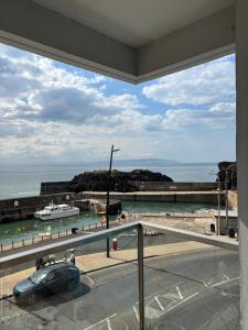 a view of a beach with a car on the street at Prime Port Apartment in Portstewart
