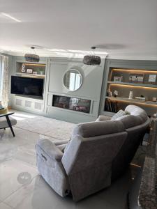 a living room with a couch and a television at Prime Port Apartment in Portstewart