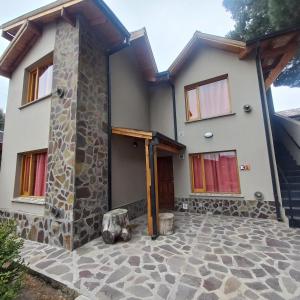a house with a stone patio in front of it at Cabañas Pailalen-Planta alta in Esquel