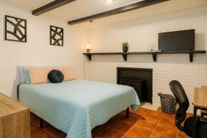 a bedroom with a bed with a tv and a fireplace at Spacious 4BR House Sleeps 9 Outdoor Lounge with Fire Pit plus Games in Raleigh