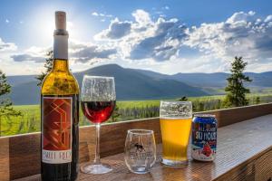 Una botella de vino y dos copas en una mesa en Moose Ridge Cabin cabin, en Grand Lake