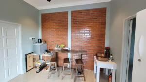 a kitchen with a brick wall and a counter with chairs at Villa RI Homes Alor Gajah in Kampong Jelatang