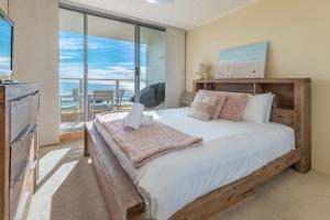 Un dormitorio con una cama grande y un balcón. en Ebbtide 8, en Forster