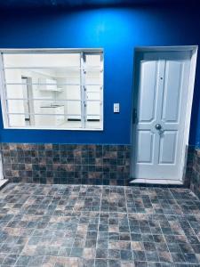a blue room with a white door and a tile floor at Casa Azul in La Quiaca