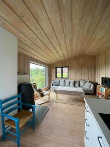 een woonkamer met een bank en een tafel bij Panoramic Cabin With Forest And Mountain Views in Sveio