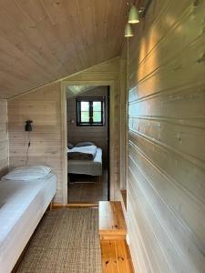 a small room with two beds and a window at Panoramic Cabin With Forest And Mountain Views in Sveio