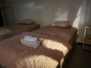 two beds in a room with towels on them at Hug Wang Homestay in Ban Nong Chaeng