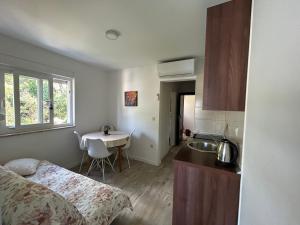 a room with a bed and a kitchen with a sink at Villa Stina Drvenik in Drvenik