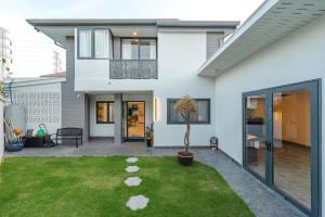 Ban Bang KhuにあるV215 ChaoFah Oasis Private Pool & Garden Retreatの庭に鉢植えの木がある白い家