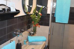 a bathroom with a sink and a vase with flowers at Invito al viaggio in Giardini Naxos