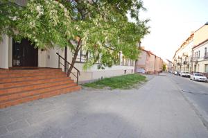 an empty street with trees and stairs next to buildings at Raugyklos g. apartment in Vilnius