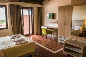 a hotel room with two beds and a desk and a mirror at Kallisti Hotel in Potos