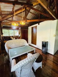 a living room with a glass table and wicker chairs at Villa Hortillosa - Your Home Away from Home in Baras
