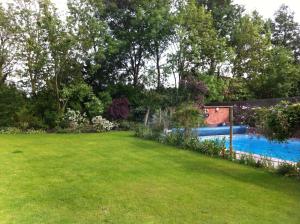 a backyard with a swimming pool and a lawn at Castle Farmhouse Bed and Breakfast in Leicester