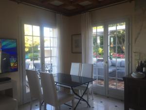 a dining room with a glass table and white chairs at Villa Manù B&B Chambre D'hote in Les Issambres