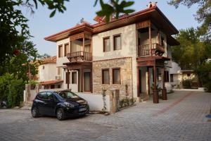 un'auto parcheggiata davanti a una casa di Alp Suites Lavanta ad Akyaka